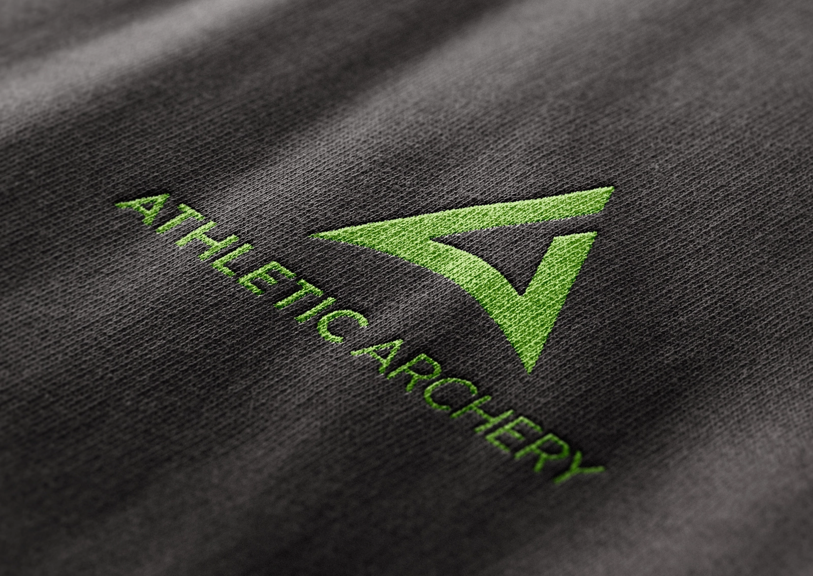 Stickerei des Athletic Archery Logos in Grün auf dunkelgrauem Stoff