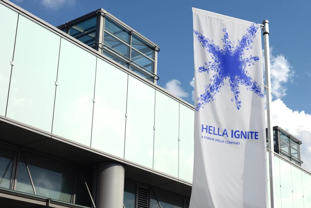 Außenaufnahme einer Fahne mit dem neuen Logo und Visual von Hella Ignite – als sichtbares Element des Rebrandings im Außenbereich
