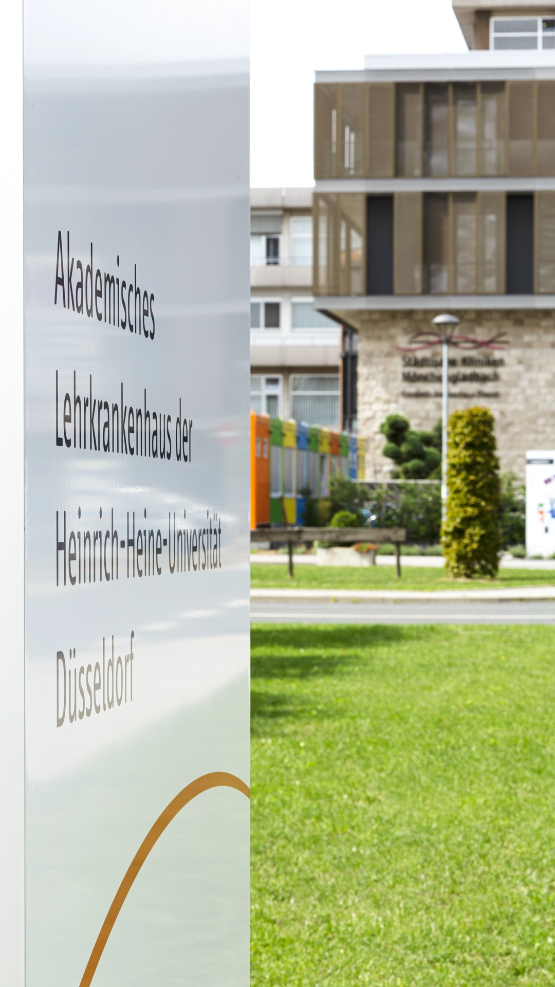 schild mit aufschrift akademisches lehrkrankenhaus der heinrich heine universität düsseldorf im vordergrund teil des orientierungssystems der städtischen kliniken