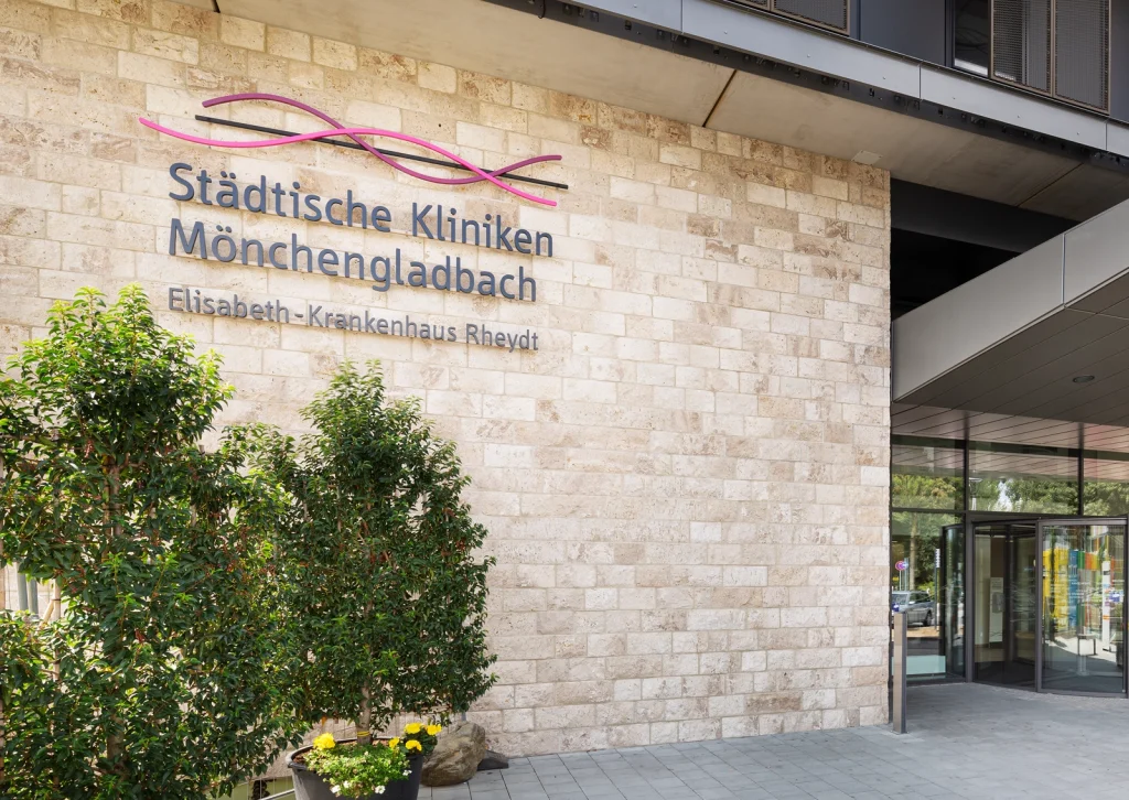Eingangsbereich der Städtischen Kliniken Mönchengladbach mit prominentem, dreidimensionalem Schriftzug auf der Wand. Konzeption und Umsetzung des Schriftzugs durch die R211-Agentur.