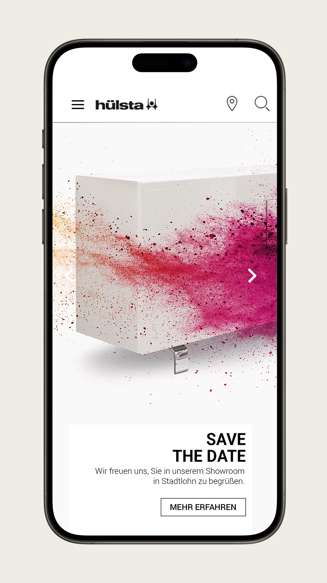 Smartphone screen with hülsta website – announcement of a showroom event in Stadtlohn, visually staged with a white furniture cube and color explosion in magenta and orange