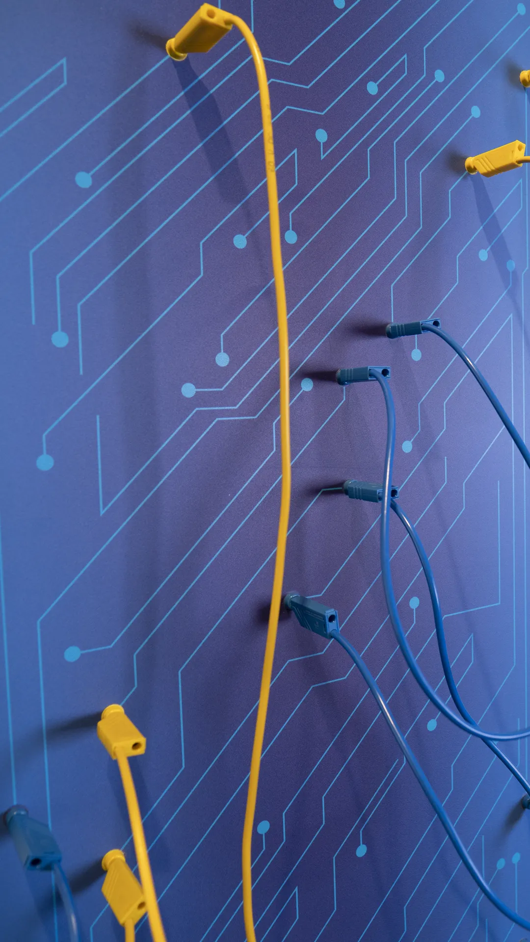Communication concept for showroom for ABUS crane systems with interactive wall with yellow and blue cables on circuit diagram graphic in the VITAL room of Abus