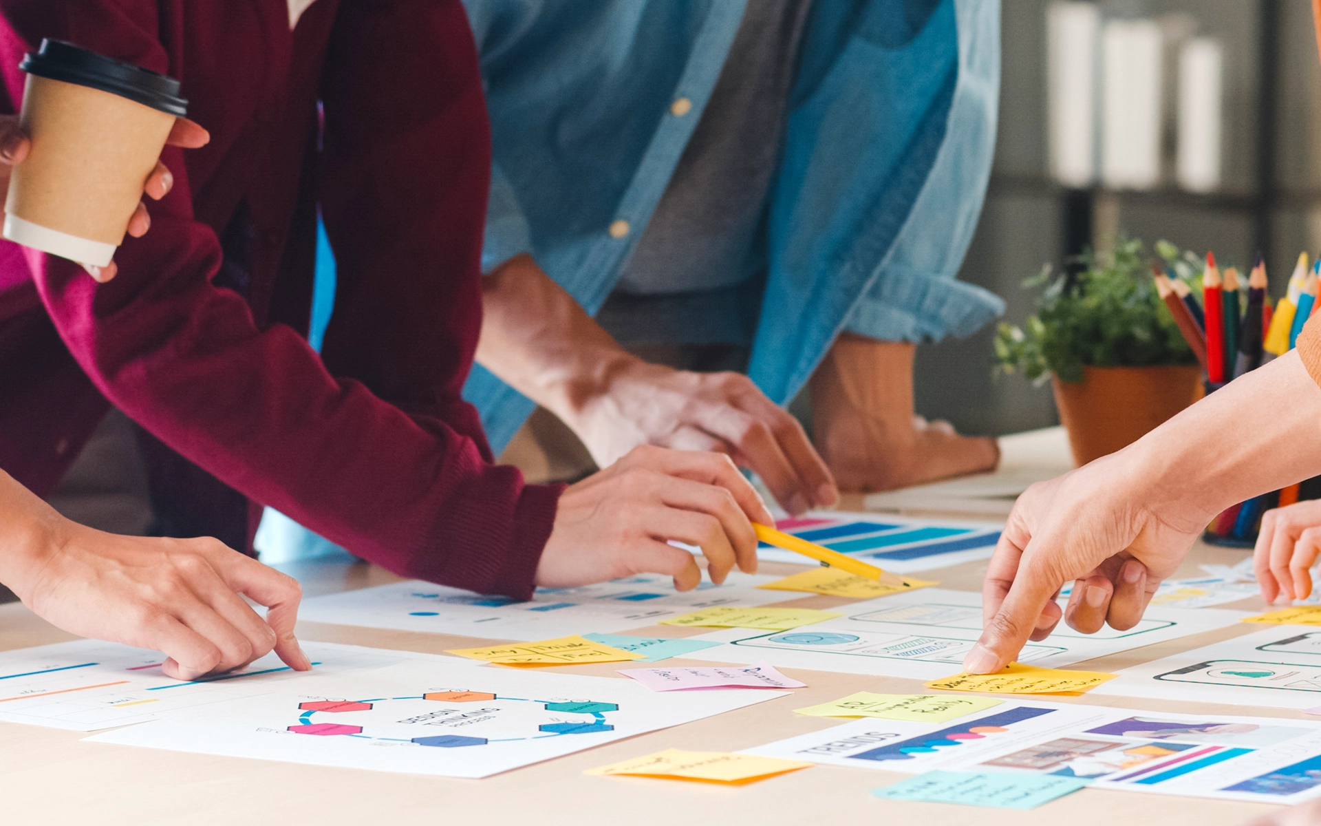 Aufnahme aus einem R211-Workshop zum Thema Creative Brief: Mehrere Personen sitzen um einen Tisch, schreiben, kleben Post-its und strukturieren Inhalte zur Briefing-Erarbeitung.