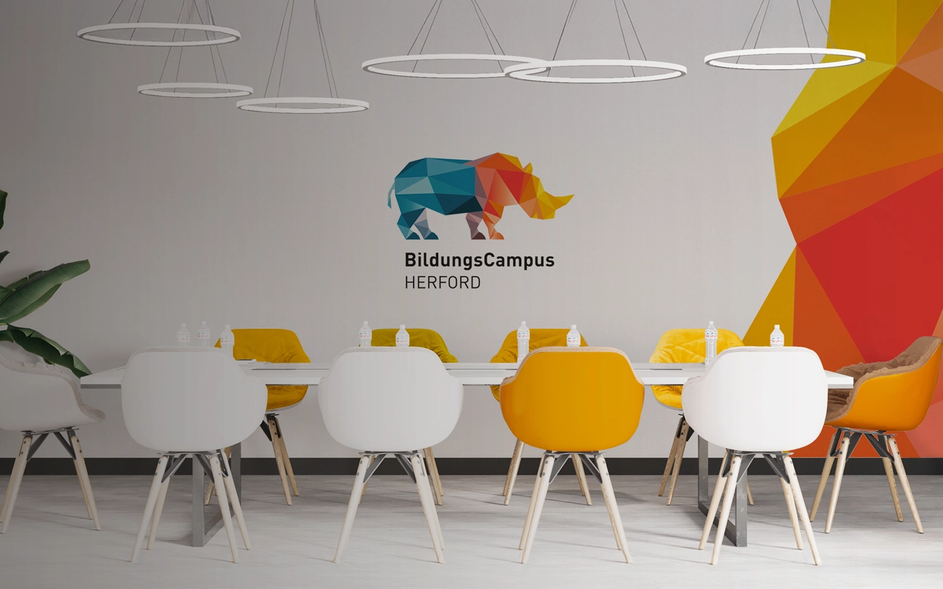 Interior shot of a conference room at the SEH BildungsCampus Herford with Branding in the background. Conception by R211 Agency.