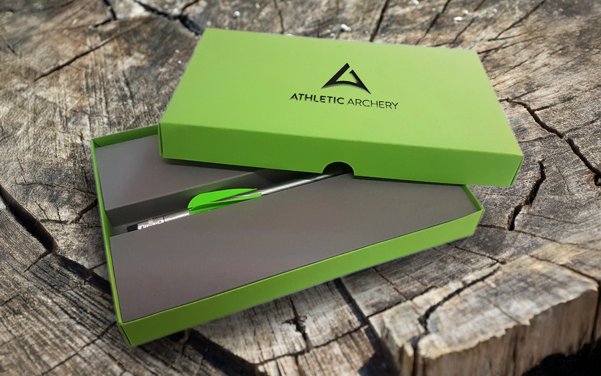 Produktaufnahme des Mailings für athletic archery mit gestalteter Verpackung und einem individuell gefertigten Stift, veredelt mit einer für den Bogensport typischen Befiederung. Gestaltung durch R211-Agentur.