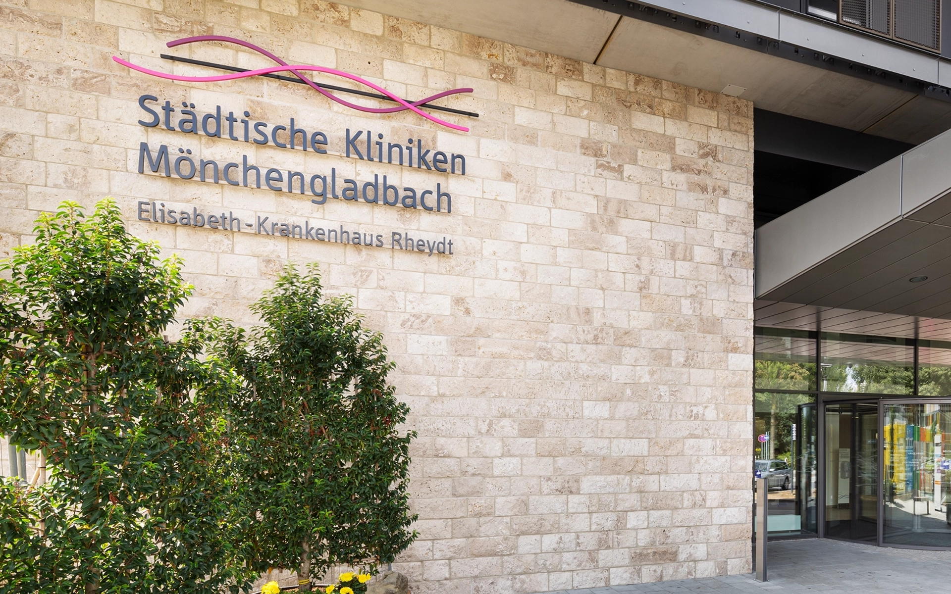 Eingangsbereich der Städtischen Kliniken Mönchengladbach mit prominentem, dreidimensionalem Schriftzug auf der Wand. Konzeption und Umsetzung des Schriftzugs durch die R211-Agentur.