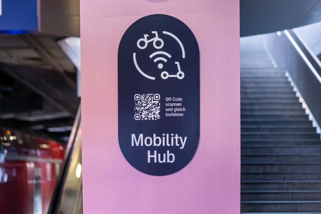 Nahaufnahme eines Piktogramms für den Mobility Hub der Deutsche Bahn, das den Übergang von Bahnreisen zu Mikromobilität wie E-Roller oder Fahrrad symbolisiert. Gestaltung durch die R211-Agentur.