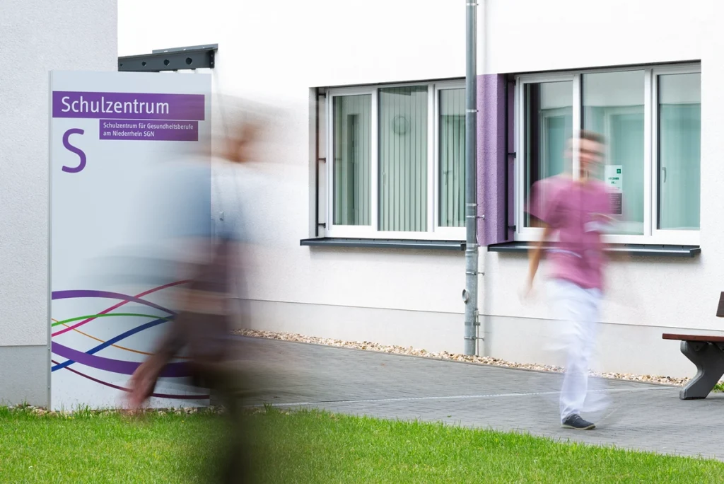 Außenaufnahme des Schulzentrums für Gesundheitsberufe am Niederrhein der Städtische Kliniken Mönchengladbach mit gut sichtbarer Gebäudebeschriftung und Beschilderung. Konzept und Umsetzung durch die R211-Agentur.