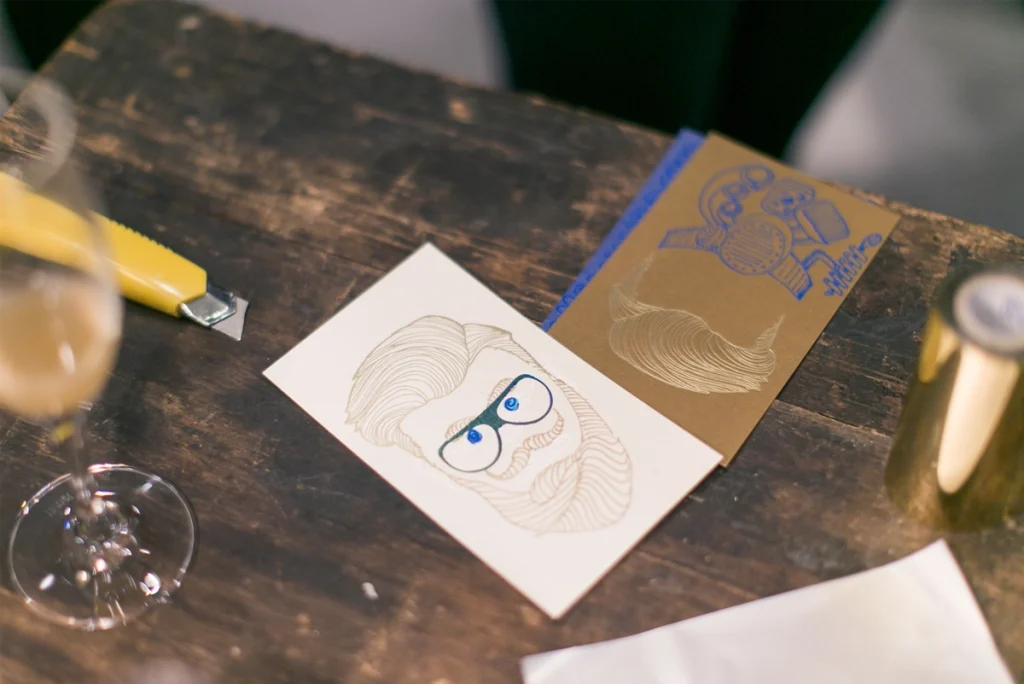 Eventtisch mit verschiedenen Papieren und Prägungen. Aufnahme vom Paper Playground Event von Freytag & Petersen, visuell gestaltet von der R211-Agentur.